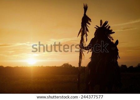 The Indians are riding a horse and spear ready to use In light of the Silhouette Royalty-Free Stock Photo #244377577