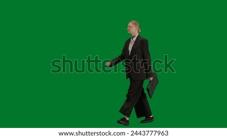 Portrait of female in suit on chroma key green screen. Blonde business woman in formal outfit walking with briefcase.
