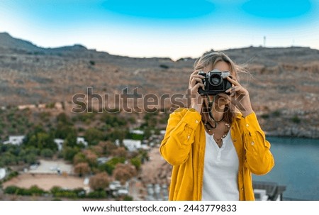 Woman photographer takes pictures on vacation.