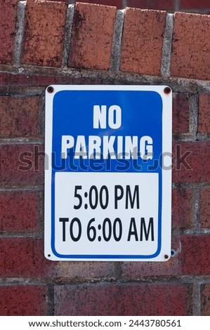 NO Parking sign on a dirty brick wall
