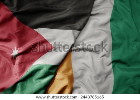 big waving national colorful flag of cote divoire and national flag of jordan. macro