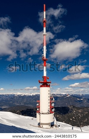 The 165m high Dobratsch Transmitter Tower, situated at an altitude of 2115m above sea level, at winter time. Royalty-Free Stock Photo #2443810175