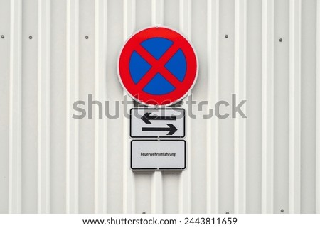 No parking sign on a white metal fence
