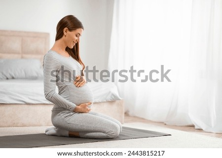 A calm pregnant woman in a peaceful state practicing prenatal yoga in her bedroom Royalty-Free Stock Photo #2443815217