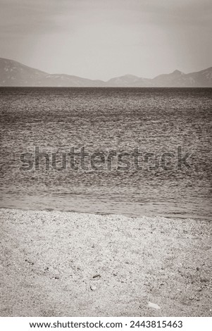 Old black and white picture of the most beautiful beaches on Kos Island in Greece with panorama view on hills and islands.