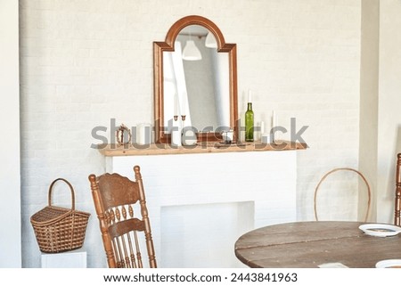 Interior design of room with fireplace, vintage mirrow, candles, wicker basket, wooden chair, table, white brick wall. Background with copy space, empty. Template, mockup for design, poster, art.