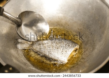 Pictures of food preparing with fried fish in the kitchen with cooking concept.