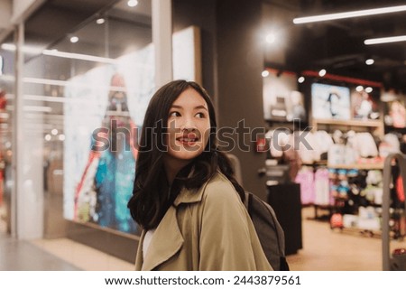 Beautiful teen girl holding shopping bags and smiling while doing shopping in mall.