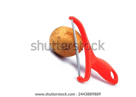 Slicing potatoes. Potato peeler. on a white isolated background. Slicer. Professional vegetable peeler for chefs with a sharp knife or stainless steel blade. Kitchen utensils for the kitchen.
