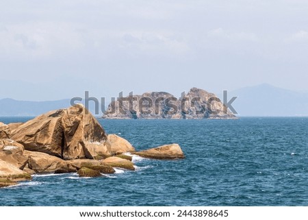 A view of the blue sea and distant islands peeking out from a corner at Ganh Den lighthouse in Phu Yen. Royalty-Free Stock Photo #2443898645