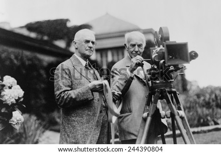 Thomas Edison 1847-1931 and George Eastman 1854-1932 standing with motion picture camera ca. 1925. Royalty-Free Stock Photo #244390804