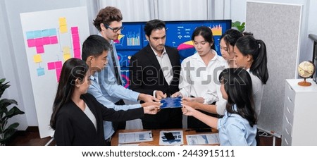 Multiethnic business people holding jigsaw pieces and merge them together as effective solution solving teamwork, shared vision and common goal combining diverse talent. Meticulous Royalty-Free Stock Photo #2443915111