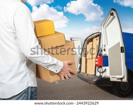 Man carries boxes into minivan. Guy is busy moving to new house. Transportation of things during relocation. Man rents car for moving. Cropped human with cardboard boxes. Moving process Royalty-Free Stock Photo #2443922629