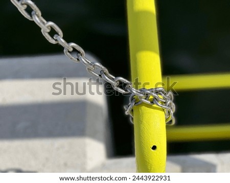 Thick metal holding a yellow metal crossbar, a chain that blocks access Safety chain, Crossbar barrier, Entry restriction, link, Barrier chain, Metal blockade, Access control chain, Yellow Royalty-Free Stock Photo #2443922931
