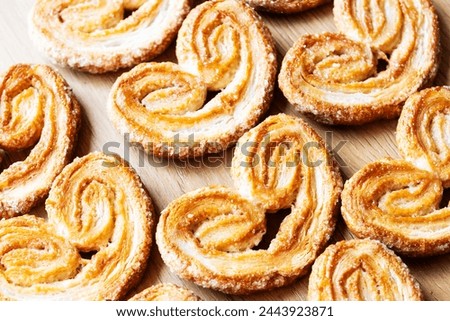 Homemade puff pastries in the shape of a heart on wooden background. Horizontal.