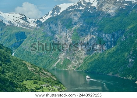 Beautiful Geiranger Fjord is a well known and popular travel destination for cruise ships and offers spectacular views to the norwegian landscape with deep gorges and snow covered mountain ranges. Royalty-Free Stock Photo #2443929155
