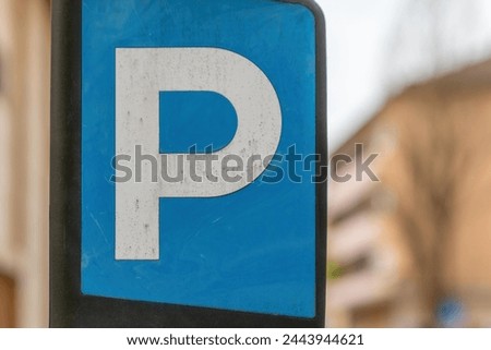 blue and white sign with the letter p on it in the city