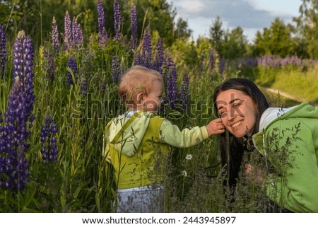 mother and child son are walking in a field of flowers