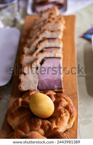 Christian Easter eggs with bread and ham prepaired for Easter breakfast on wooden plate
