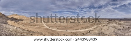 Panoramic drone picture over a gravel road near Fish River Canyon in southern Namibia under a blue sky in summer