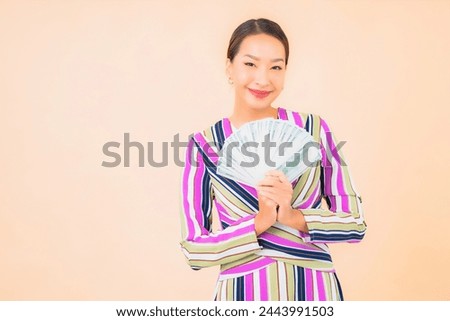 Portrait beautiful young asian woman with cash or money and mobile smart phone on color isolated background