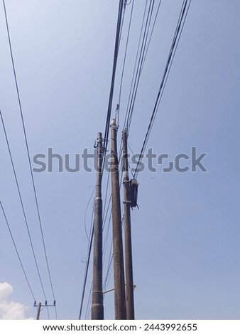 some power poles are strong standing under the beautiful blue sky and hot of the sun to prop some electric cables that's long and heavy