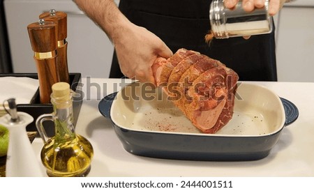 A man prepares meat for cooking generously sprinkling seasoning The seasoning enhances flavor and aroma ensuring a delicious outcome. With the right seasoning, dish becomes irresistible and satisfying