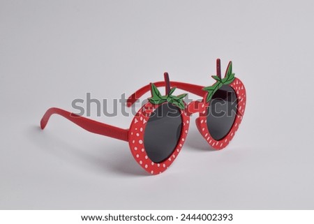Red strawberry glasses on white background. For a birthday, disco party, carnival, festival