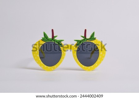 Yellow strawberry glasses on white background. For a birthday, disco party, carnival, festival