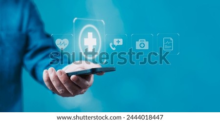 A man is holding a cell phone with a medical symbol on it. Concept of healthcare, insurance, health, healthcare and the importance of technology in the field