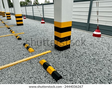 Large truck parking structure, cement pillars, yellow and black lines. Royalty-Free Stock Photo #2444036267