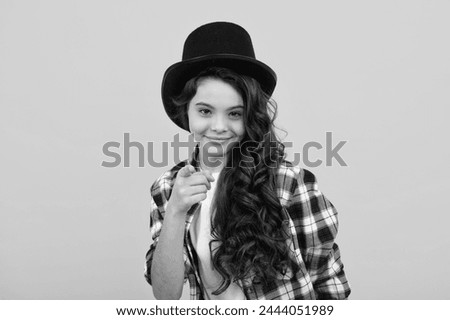 Teenager girl in magician hat, cylinder hat isolated on yellow background. Headwear. Clothes accessories. Fashion headwear for gentlemen in vintage style, old classic cylinder. Royalty-Free Stock Photo #2444051989