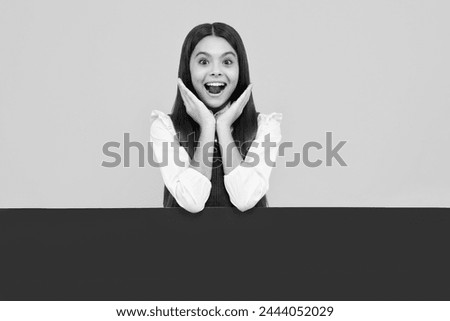 Teenage girl holds a blank for notification informing. Advertisement and sale. Markets and shops sales concept, blank board for copy space. Excited face, cheerful emotions of teenager girl.