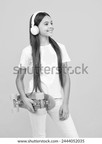 Teen girl 12, 13, 14 years old with skateboard over studio background. Cool modern teenager in stylish clothes. Teenagers lifestyle, casual youth culture. Happy teenager portrait.