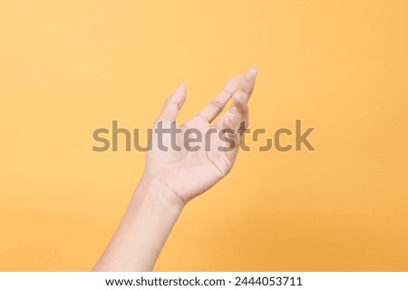 Woman hand gesture isolated on a yellow studio background