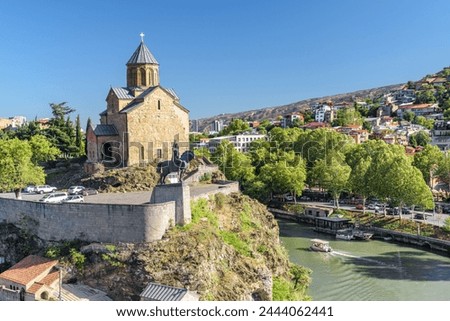 Awesome view of the Virgin Mary Assumption Church of Metekhi on the cliff over the Kura (Mtkvari) River in Tbilisi, Georgia. The Georgian Orthodox Christian church is a popular tourist attraction. Royalty-Free Stock Photo #2444062441