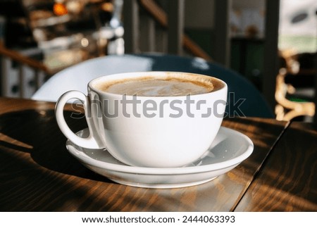 Cup of hot coffee on table in cafe. No people. Latte or cappuccino coffee cup at cafe table.