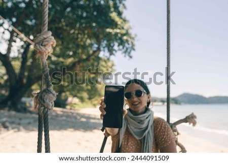 person showing phone on the beach
