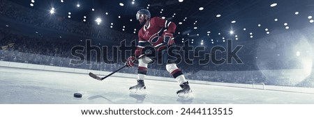 Dynamic image of competitive man, professional hockey player in uniform in motion during tournament, with puck and stick on 3d render ice rink. Concept of sport, competition, match, game, tournament Royalty-Free Stock Photo #2444113515