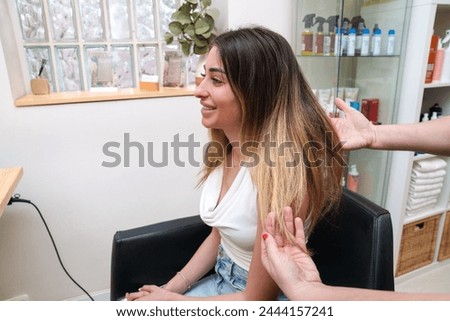Client smiles while hair health is assessed before stem cell treatment Royalty-Free Stock Photo #2444157241