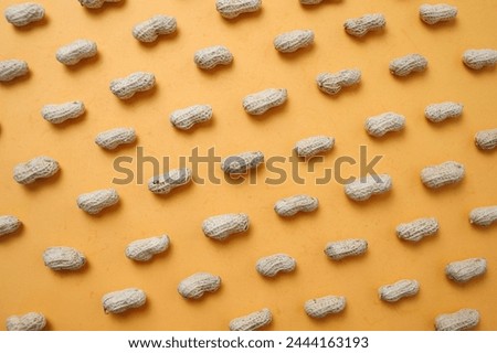 Top view of fresh peanuts in shells forming seamless pattern on yellow background Royalty-Free Stock Photo #2444163193