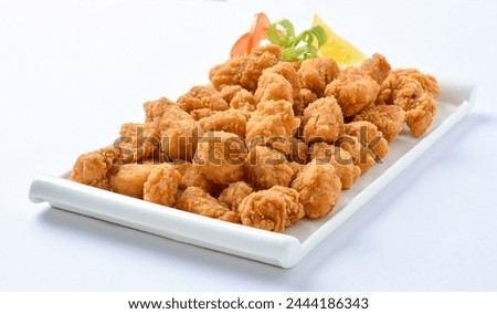 Chicken Hot Shots or Chicken Tenders. Small boneless chicken cubes marinated and coated with bread crumb. Quick and delicious snack. Royalty-Free Stock Photo #2444186343