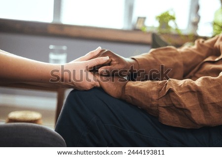Female healthcare worker holding hands of senior man at care home, focus on hands. Providing necessary support. Close-up of unrecognizable woman holding hand of African senior man