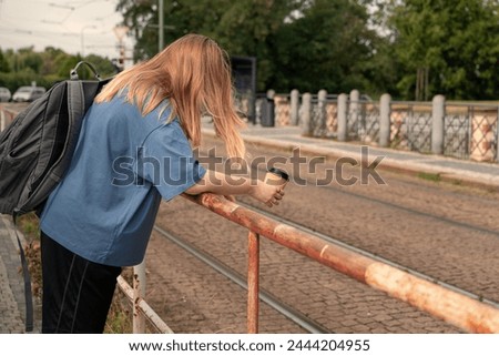 Tired woman holding coffee mug, hungover tourists in city center, sightseeing tourists having high Morning after, Leisure, Exhaustion, Urban excursion, Weariness, Urban tourism, Tourist activity Royalty-Free Stock Photo #2444204955