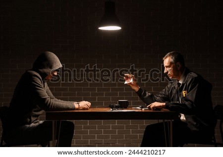 Mature FBI agent questioning suspect in interrogation room