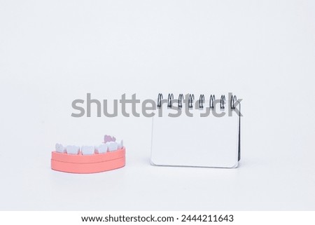 wooden dental jaw teeth on white background with note book