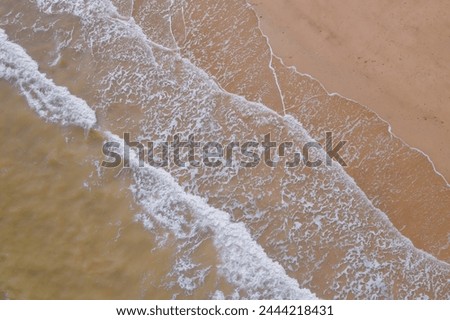 Gentle Waves Caressing Sandy Beach from Above