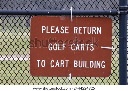 A sign that says "please return golf carts to cart building".