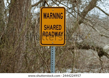 A sign warning pedestrians of the shared roadway.