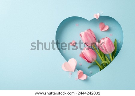 Mother's Day finesse concept. Top view shot of blooming tulips, decorative hearts, modern confetti, showcased within heart-shaped cutout on chic blue background, leaving space for customized promotion